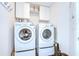 Well-equipped laundry room featuring a washer, dryer, and ample storage cabinets for convenience at 1603 Scotch Pine Dr, Brandon, FL 33511