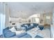 Spacious living room with a large blue sectional, white rug, and open floor plan connected to a modern kitchen at 1603 Scotch Pine Dr, Brandon, FL 33511