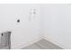 Clean laundry room hook-ups feature a modern gray-toned wood-look flooring and white walls at 16134 Libourn Ave, Port Charlotte, FL 33954