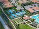 Aerial view of community amenities, including pool, tennis courts, and bocce ball, surrounded by lush landscaping at 17319 Holly Well Ave, Wimauma, FL 33598