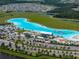 Aerial view of a large community lagoon with beach access, water sports, and surrounding residential area at 17319 Holly Well Ave, Wimauma, FL 33598
