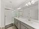 Bathroom featuring double sinks, glass enclosed shower, and natural lighting at 17319 Holly Well Ave, Wimauma, FL 33598