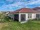 Rear exterior of home featuring a screened in patio and lush green lawn at 17319 Holly Well Ave, Wimauma, FL 33598