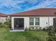 Home's rear exterior featuring a screened in patio and a green lawn at 17319 Holly Well Ave, Wimauma, FL 33598