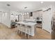 The kitchen offers a central island with seating, stainless steel appliances, and ample counter space at 17319 Holly Well Ave, Wimauma, FL 33598