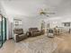 Bright living room featuring a ceiling fan, sliding glass doors and an open floor plan at 17319 Holly Well Ave, Wimauma, FL 33598