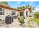 Outdoor view of the home featuring a patio, grill, and lush landscaping at 1880 Oak Bark Ct, Clearwater, FL 33763