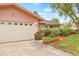 Well-kept home featuring an attached garage, colorful plants, and lush shrubbery at 1880 Oak Bark Ct, Clearwater, FL 33763