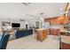Open layout with a kitchen with wooden cabinets, a center island, and a living room with a blue sofa at 1880 Oak Bark Ct, Clearwater, FL 33763
