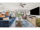 Inviting living room with blue sofa, ceiling fan, sliding glass door to backyard, and an entertainment center with large TV at 1880 Oak Bark Ct, Clearwater, FL 33763