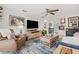 Open-concept living room featuring a leather recliner, a textured rug, and stylish decor including wall art and a ceiling fan at 1880 Oak Bark Ct, Clearwater, FL 33763