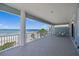 Expansive balcony showcasing ocean view, tile flooring, white columns, and comfortable lounge chairs at 2 Gulf Blvd, Indian Rocks Beach, FL 33785
