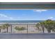 Stunning beach view from balcony featuring white railings, palm trees, and the ocean at 2 Gulf Blvd, Indian Rocks Beach, FL 33785