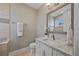 Elegant powder room features a marble countertop, white vanity, and decorative mirror for a sophisticated touch at 2 Gulf Blvd, Indian Rocks Beach, FL 33785