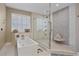 Serene bathroom featuring a glass shower, soaking tub, and a window with natural light at 2 Gulf Blvd, Indian Rocks Beach, FL 33785