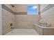 Bright bathroom with a soaking tub, neutral tiling, and decorative accent tiles for a spa-like experience at 2 Gulf Blvd, Indian Rocks Beach, FL 33785