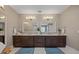 Bathroom boasts dual sinks, elegant mirrors, stylish sconces, and abundant storage in dark wood cabinets at 2 Gulf Blvd, Indian Rocks Beach, FL 33785