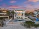 Aerial view of a three-story coastal home with a pool, spa, and beach access at 2 Gulf Blvd, Indian Rocks Beach, FL 33785