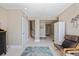 Beige foyer with blue rug, wooden stairs and white storage cabinet at 2 Gulf Blvd, Indian Rocks Beach, FL 33785