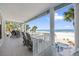 Covered patio with comfortable lounge chairs overlooking a beautiful ocean view and nearby pool at 2 Gulf Blvd, Indian Rocks Beach, FL 33785