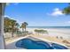 Beautiful beachside pool with palm trees and white picket fence overlooking the ocean at 2 Gulf Blvd, Indian Rocks Beach, FL 33785