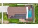 Aerial view of a home with solar panels and screened in pool on a well manicured lot at 2330 Lawrence Hall St, Ruskin, FL 33570