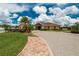 Landscaped entrance to community clubhouse with brick pathway, manicured lawn and palm trees at 2330 Lawrence Hall St, Ruskin, FL 33570