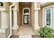 Inviting front entrance with brick-paved walkway, white columns, and decorative glass door at 2330 Lawrence Hall St, Ruskin, FL 33570