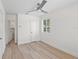 Bright bedroom with light wood floors, a ceiling fan, a window with blinds, and white walls at 2449 16Th N St, St Petersburg, FL 33704