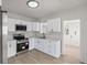 Modern kitchen featuring stainless steel appliances, bright white cabinets, and new flooring at 2449 16Th N St, St Petersburg, FL 33704