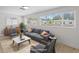 Bright living room featuring a comfortable gray sofa, stylish furniture, and plenty of natural light from large windows at 2449 16Th N St, St Petersburg, FL 33704