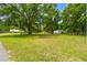 Spacious backyard with lush lawn, mature trees, and secure fencing creating a private oasis at 25623 Inkwood Pl, Wesley Chapel, FL 33544