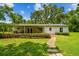 Well-maintained backyard with lush green lawn and a stone walkway to the house at 25623 Inkwood Pl, Wesley Chapel, FL 33544
