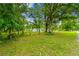 Expansive backyard with mature trees and fencing offering privacy and a tranquil outdoor space at 25623 Inkwood Pl, Wesley Chapel, FL 33544
