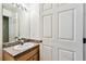 Bathroom featuring a sink, vanity, mirror, and a door at 25623 Inkwood Pl, Wesley Chapel, FL 33544