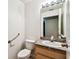 Well-lit bathroom featuring a toilet, sink, vanity, mirror, and grab bar at 25623 Inkwood Pl, Wesley Chapel, FL 33544