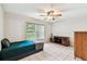 Bedroom featuring tile flooring, a ceiling fan, a bed and a window with natural light at 25623 Inkwood Pl, Wesley Chapel, FL 33544