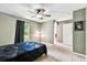 Cozy bedroom with large window, ceiling fan, and access to en-suite bathroom at 25623 Inkwood Pl, Wesley Chapel, FL 33544