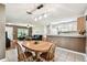 Dining area with a round wooden table and chairs with an open view to living area at 25623 Inkwood Pl, Wesley Chapel, FL 33544