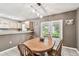 Dining area with backyard view through french doors, wooden table with 4 wooden chairs at 25623 Inkwood Pl, Wesley Chapel, FL 33544