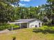 Single-story home features a covered carport and lush greenery at 25623 Inkwood Pl, Wesley Chapel, FL 33544