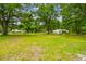 Expansive front yard showcasing a large lot, mature trees, and a fenced perimeter, offering privacy and curb appeal at 25623 Inkwood Pl, Wesley Chapel, FL 33544