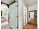 Hallway view showing bathroom entrance and transition to living space with wood floors at 25623 Inkwood Pl, Wesley Chapel, FL 33544