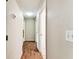 Hallway with wooden floors leading to multiple rooms and features light-colored walls at 25623 Inkwood Pl, Wesley Chapel, FL 33544