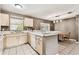 Open kitchen with a breakfast bar and dining area, featuring light wood cabinets and bright, natural lighting at 25623 Inkwood Pl, Wesley Chapel, FL 33544