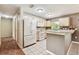 Bright kitchen featuring white appliances, white tile floors, and wooden cabinets at 25623 Inkwood Pl, Wesley Chapel, FL 33544