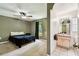 View of the main bedroom, including bathroom access, natural light, and ceiling fan at 25623 Inkwood Pl, Wesley Chapel, FL 33544