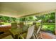 Covered patio with table, chairs, and a view of the landscaped backyard at 25623 Inkwood Pl, Wesley Chapel, FL 33544