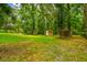 View of the backyard featuring two storage sheds surrounded by mature trees and a green lawn at 25623 Inkwood Pl, Wesley Chapel, FL 33544