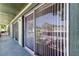 View from balcony shows sliding glass doors with vertical blinds, with lush foliage in the distance at 2932 Lichen Ln # D, Clearwater, FL 33760